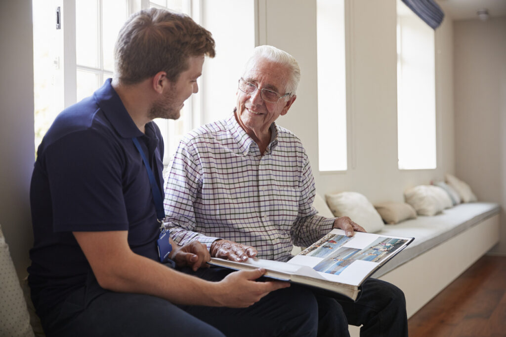 Senior Man Looking at Photo Album with Adult Child
